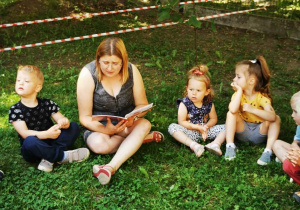 Ciocia Agnieszka w ogrodzie przedszkolnym czyta książeczki
