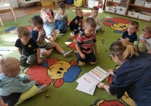 Dzieci dotykają magicznej książki "nacisnij mnie"