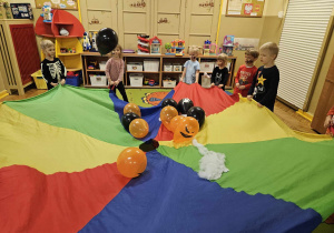 wspólna zabawa dzieci z chustą animacyjną i balonami