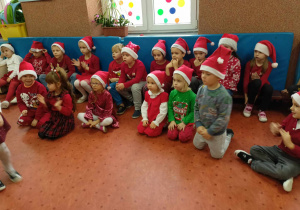 Dzieci siedzą i słuchają jak obchodzimy Imieniny Mikołaja