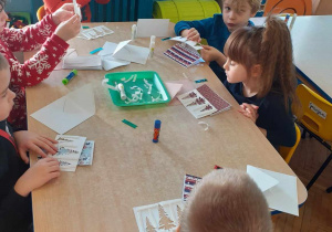 Dzieci aktywnie przy stoliku tworzą swoje kartki