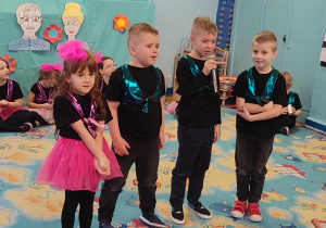 Czwórka dzieci wypowiada wierszyki do mikrofonu